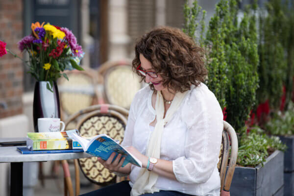 Nysie Henry sitting at a table reading a book.