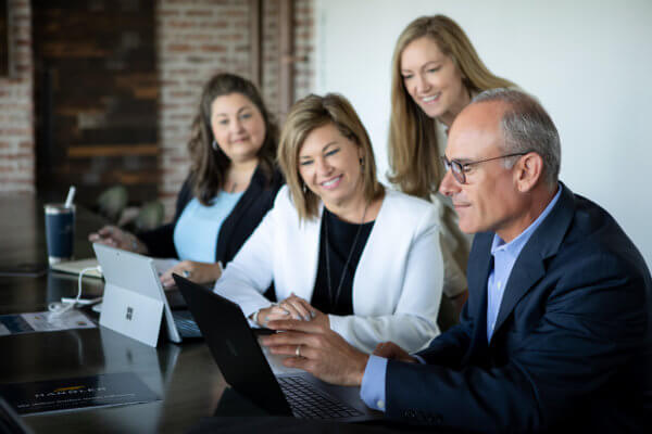 Handler team sitting around desk talking about recruitment process outsourcing.