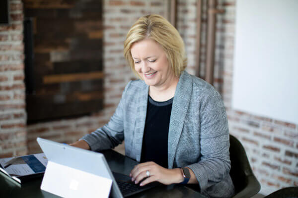 Christi Howard sitting at table on laptop