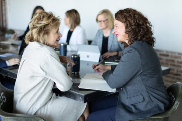 Two members of Team Handler, recruiting firm in Atlanta, are sitting at a meeting table discussing their next search