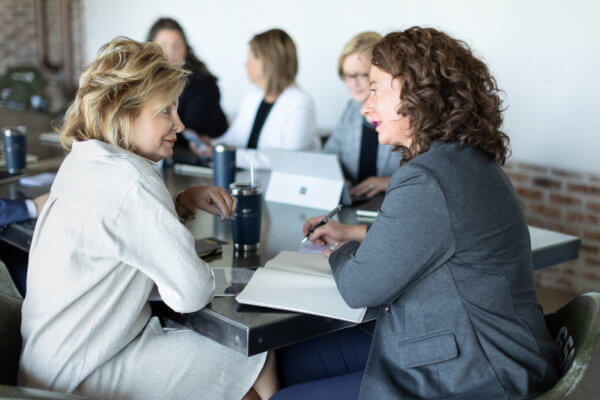 Two members of Team Handler, recruiting firm in Atlanta, are sitting at a meeting table discussing their next search