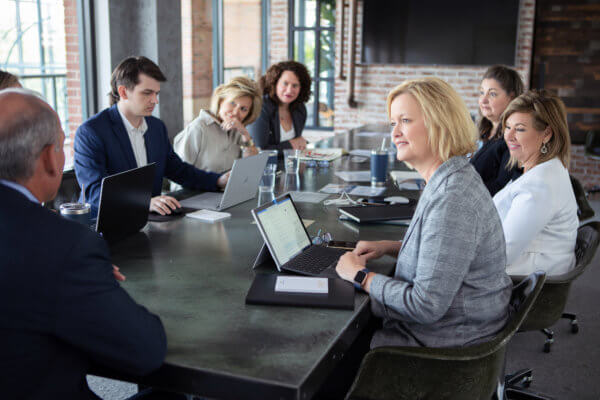 Handler team sitting around desk talking