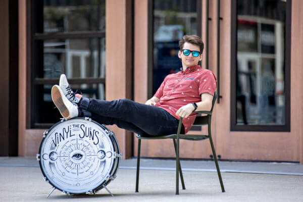 jack Lloyd sitting in a chair, legs propped up on a bass drum.