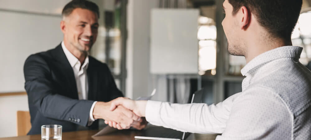 Two men shaking hands in interview hiring around values