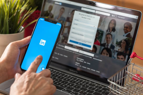 Person holding phone that shows LinkedIn app open