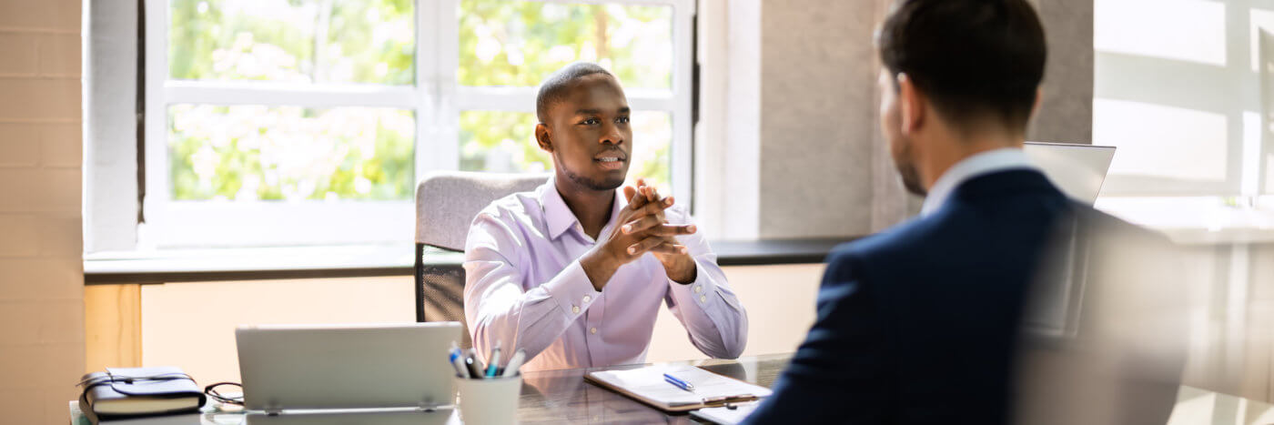 Two men in a meeting at the office talking about recruiting trends for the year