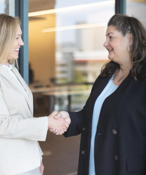 Two women shaking hands - Whitefield Academy, handler recruiting
