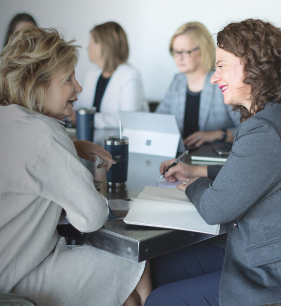 Two members of Team Handler, recruiting firm in Atlanta, are sitting at a meeting table discussing their next search