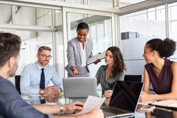 Group of diverse leaders sitting around conference table talking about speaking like a leader