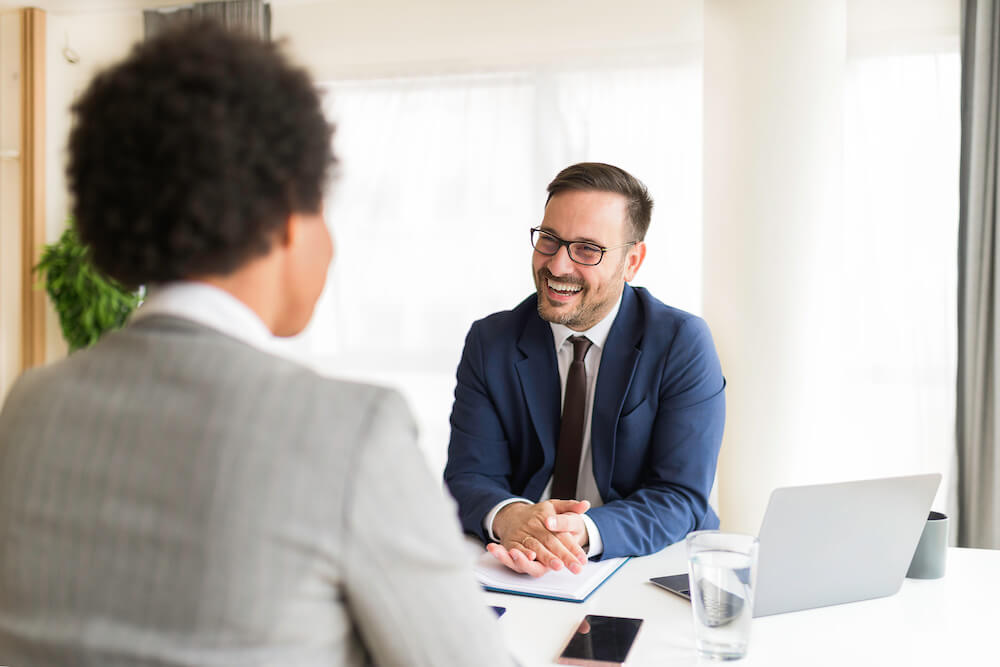 Man smiling while across the table from someone during an executive interview