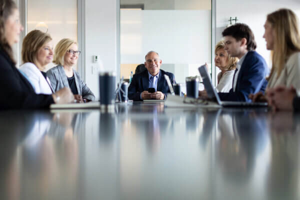 Eric Handler at the head of an office table talking to his team about leading in constant change